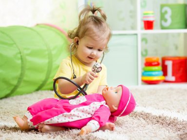 Girl playing doctor with doll - Pediatric Associates of Franklin